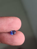 GS-000004 oval blue sapphire held between fingers — owner photograph